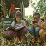 Para pelajar di Desa Bukit Temulawak, Yogyakarta mengikuti kelas daring selama pandemi, menggunakan telepon genggam dengan akses internet yang masih terbatas (AFP).